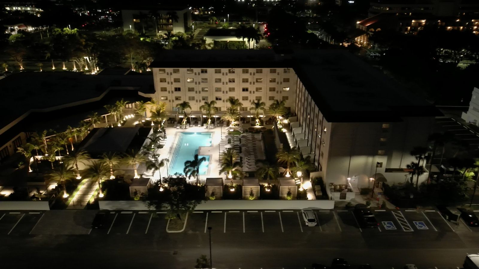 Hotel pool courtyard after renovation, aerial at night